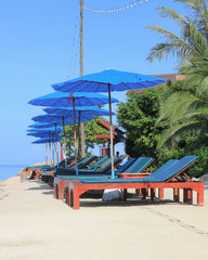 beds and umbrella beside beach