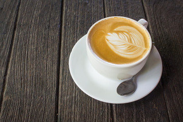 Cup of latte coffee on wood