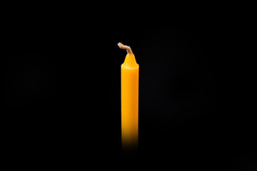 Yellow candle into black background