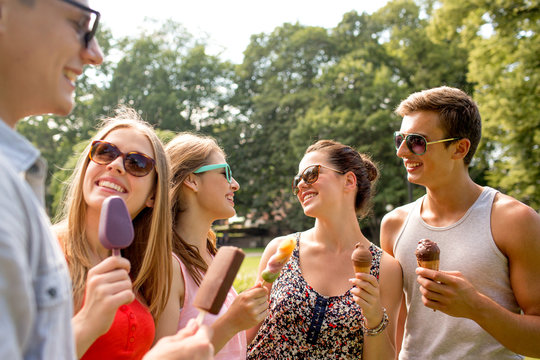 group of smiling friends with ice cream outdoors