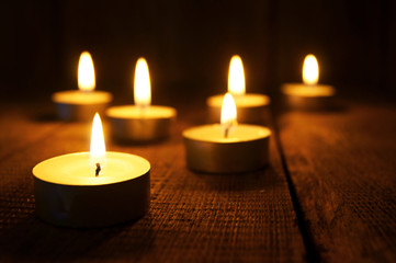 Fototapeta na wymiar Burning candles. On wooden background.