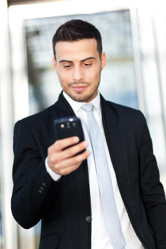 Portrait of a young businessman texting on the phone