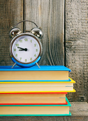 Naklejka premium Alarm clock and books.