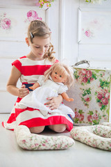 Young girl in a dress, playing with her doll