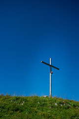 Fototapeta na wymiar Crucifix on the top of the mountain in the middle of a meadow