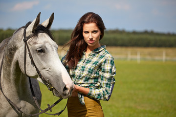 Obraz premium An attractive young woman with a horse