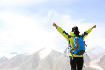 young woman open arms to snow mountain in tibet,china