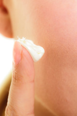 Skin care. Moisturizing cream on female finger