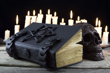 Magic book with candles and skull