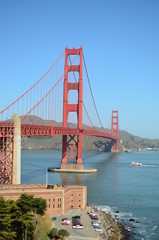 Golden Gate Bridge, a fort, surfers on a clear San Francisco day