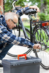 Older man repairing a bicycle