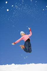 Fototapeta na wymiar Österreich,Mädchen springt im Schnee