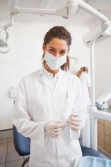 Fototapeta na wymiar Dentist examining her tools on a tray looking at camera
