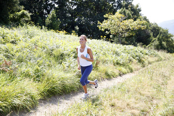 Obrazy na Szkle  Wysportowana kobieta biegająca na wsi