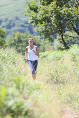 Athletic woman running in countryside