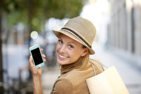 Smiling Shopping Girl Using Smartphone In Town
