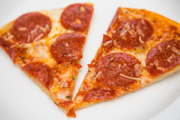 Two Slices of Pepperoni Pizza on White Plate