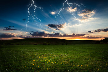 Thunderstorm with lightning in green meadow