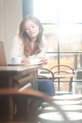 frau mit kaffe tasse und leptop