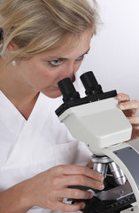 Wissenschaftlerin schaut ins Mikroskop in einer Labor