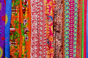 Rows of colourful silk scarfs hanging at a market stall in Thail