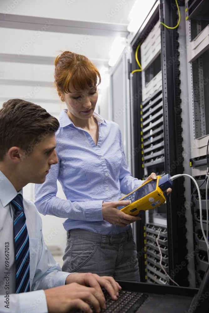 Aufkleber team of technicians using digital cable analyser on servers