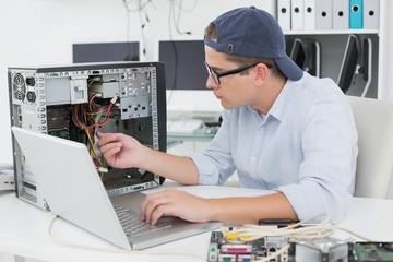 Fototapeta na wymiar Computer engineer working on broken console with laptop