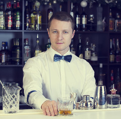 young man working as a bartender in a nightclub bar