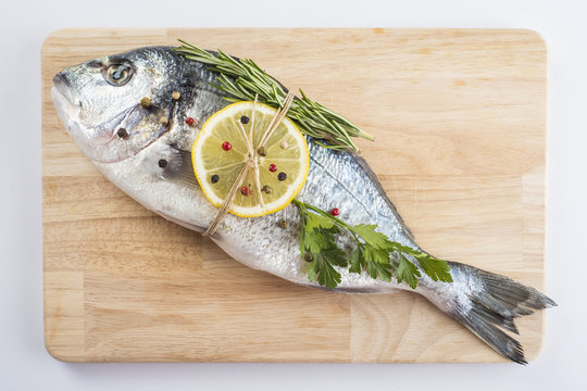 Preparaci&oacute;n del pescado fresco con especias y lim&oacute;n para cocinar