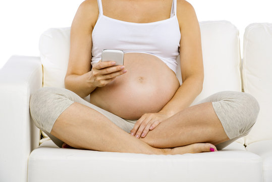 Unrecognizable pregnant woman with smartphone