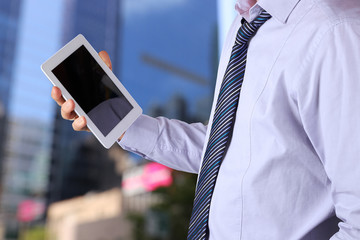 Businessman holding  and using the digital tablet. Modern city b