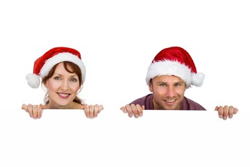 Couple both wearing santa hats
