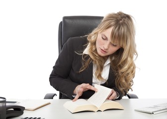 Young businesswoman paging through a book