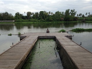 Man sitting in Thai river terrace - feel lonely