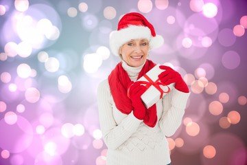 Composite image of festive woman holding gift