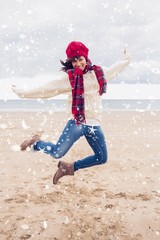 Fototapeta na wymiar Woman in stylish warm clothing jumping at beach