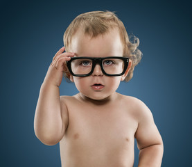 Cute little nerd boy wearing glasses isolated on blue backgroun
