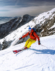 Skier skiing downhill in high mountains 