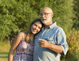 Outdoor portrait of  grandfather with granddaughter.