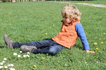 Blond Kid sitting on the grass - tuscany italy