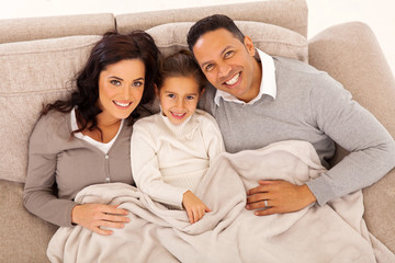 top view of young family lying on the couch