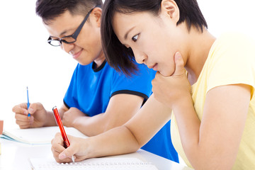 two young students exams together in classroom