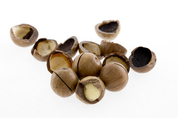 Shelled and unshelled macadamia nuts on white background