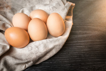 Chicken brown eggs in sackcloth on wooden background