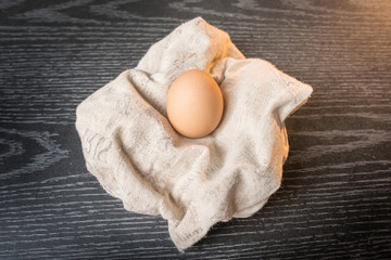 Chicken brown eggs in sackcloth on wooden background