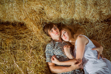 Naklejka na ściany i meble Young boy and gyrl lying in hay