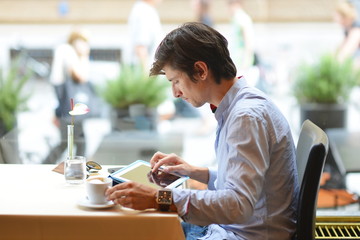 Young fashion man / hipster drinking coffee with tablet computer