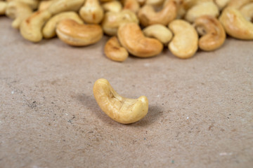 One roasted cashew and cachews on background