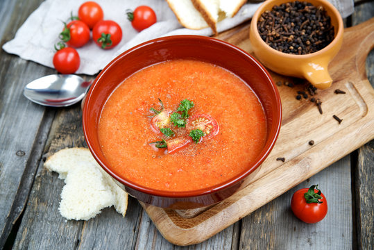 Tomato soup with spices on a wooden background