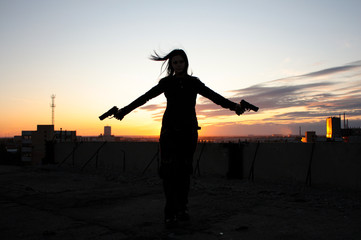Girl with guns in abandoned ruins